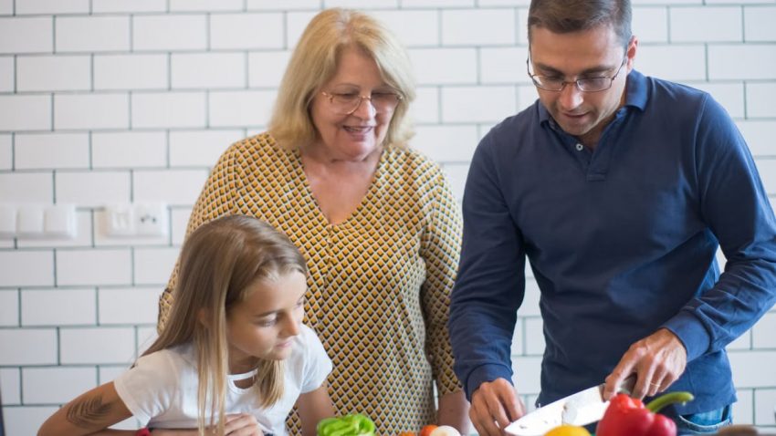 A family happily preparing vegetables together in a modern kitchen.